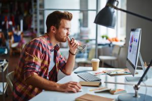 Modern designer sitting in front of computer in office