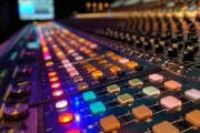 Close-up of a sound mixing console with colorful illuminated controls