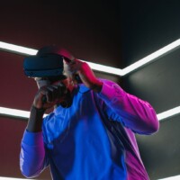 Person wearing a virtual reality headset beneath geometric LED lights