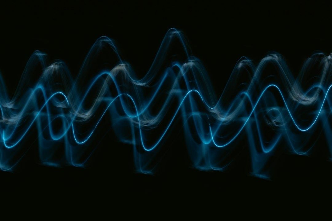Blue glowing waveforms undulate across a black background