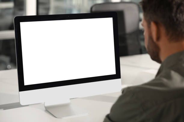 Person viewing a blank desktop monitor at a workstation